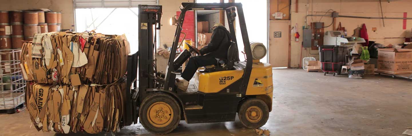 fork lift moving cardboard boxes for recycling in arkansas