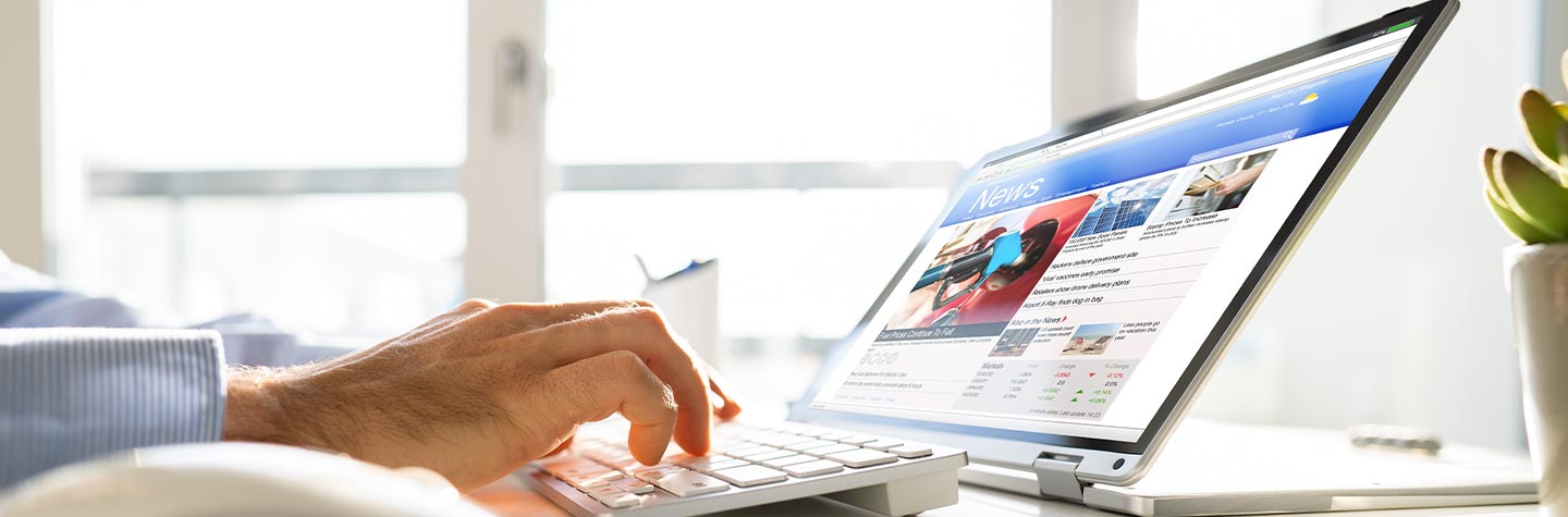 laptop and person searching news stories