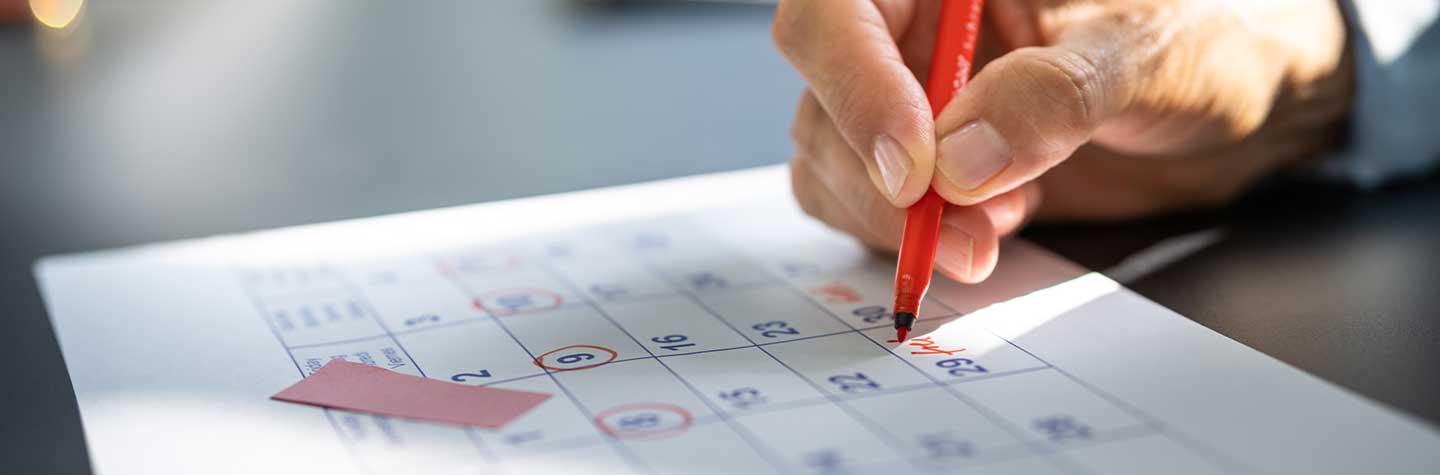 person writing on a calendar date